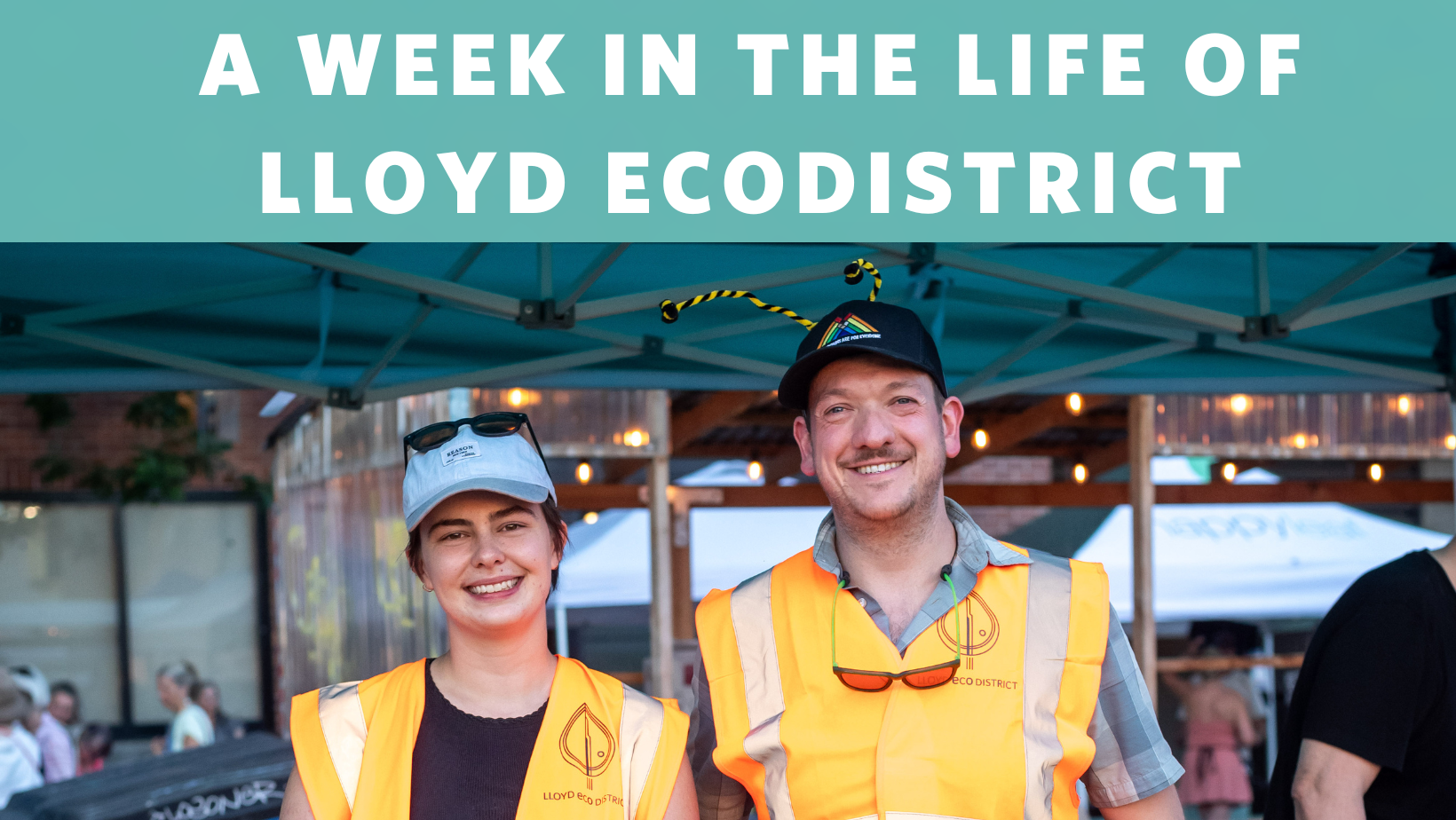 Picture of two Lloyd EcoDistrict staff (one Caucasian woman and one Caucasian man). They are standing up at a block party event, where orange safety vests, and looking at the camera.