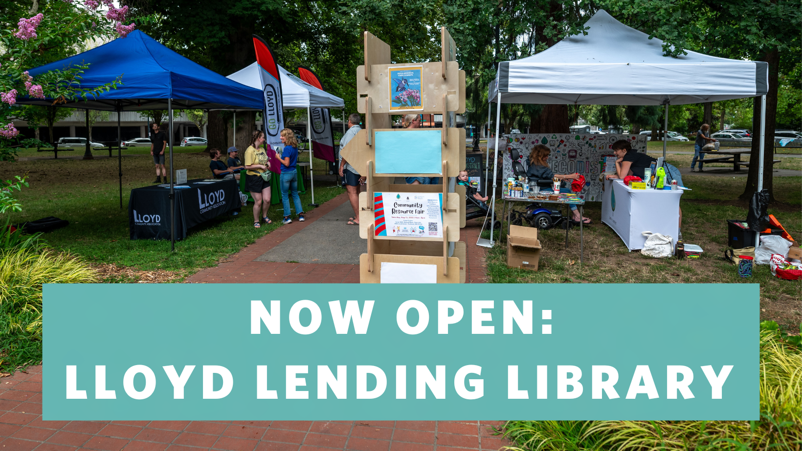 A picture of a Lloyd EcoDistrict event in Holladay Park featuring multiple tent canopies and the words "Now Open: Lloyd Lending Library" overlaid.