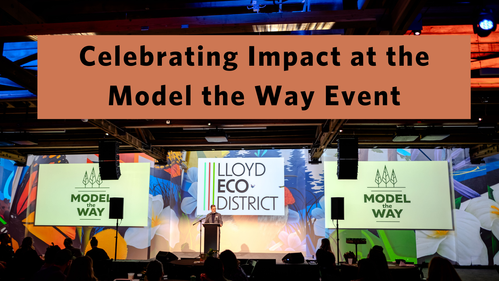 Image of the stage at Model the Way with a man speaking at the podium and the words “Celebrating Impact at the Model the Way Event”