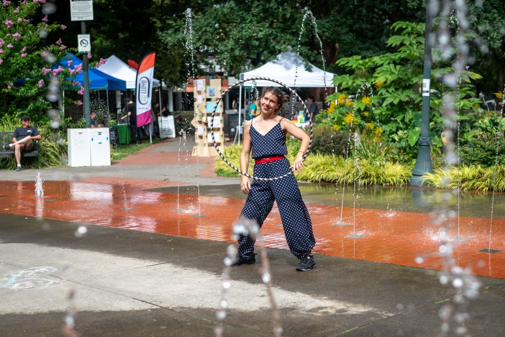 an image of an woman holding a hula hoop in Holladay Park.