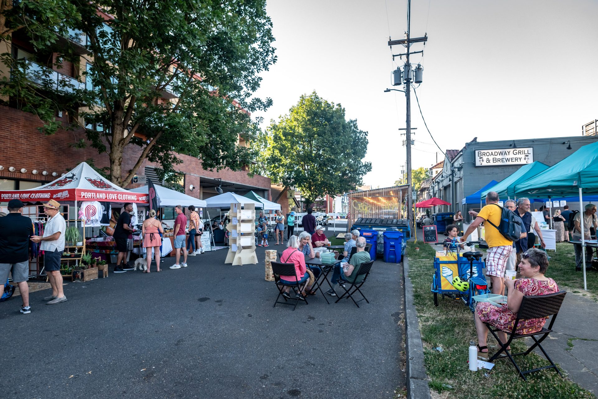 a photo of people sitting at table at a block party