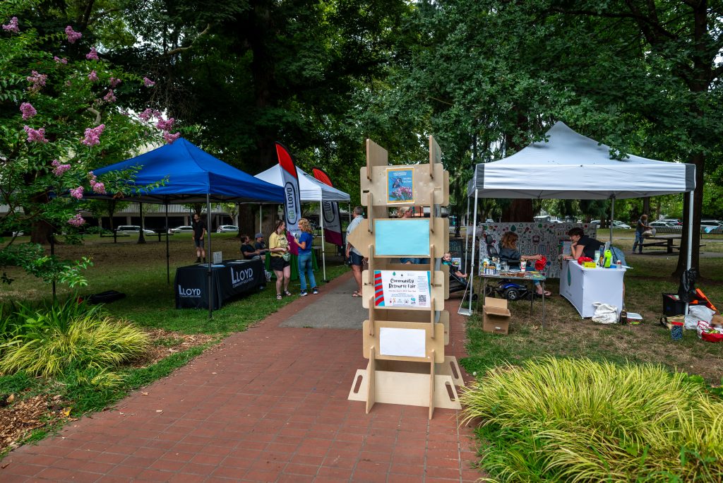 the picture contains some items from the lending library like the community engagement board and canopy tents.
