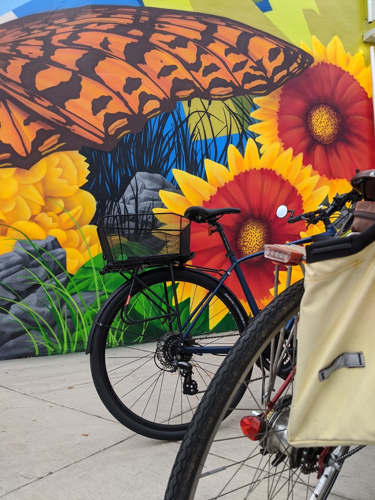 A bicycle in front of a colorful mural.