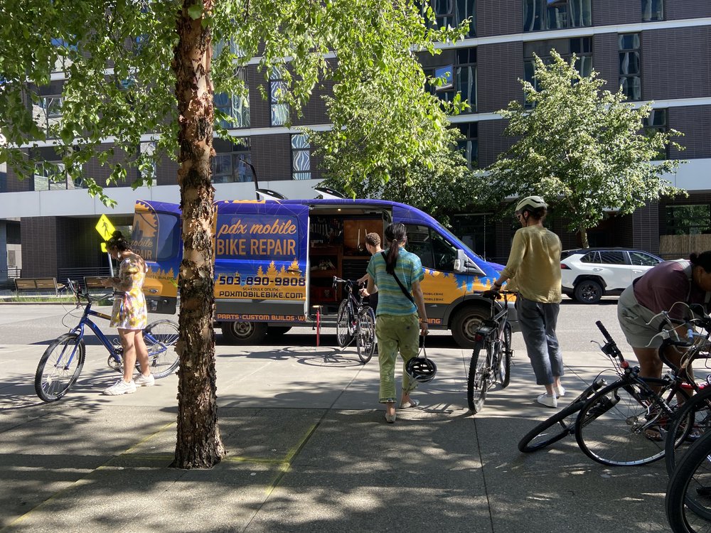 A picture of people getting their bikes repaired.