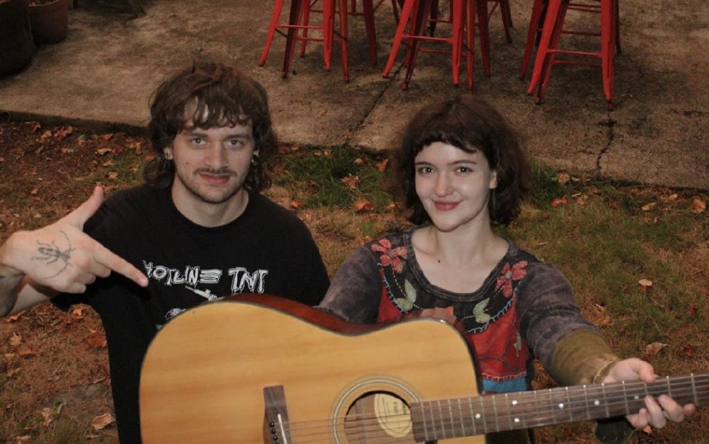 a photo Sarabean and Brood22 with Sarabean holding a guitar.