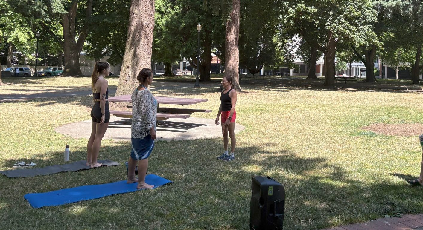 image of three people doing yoga in the park