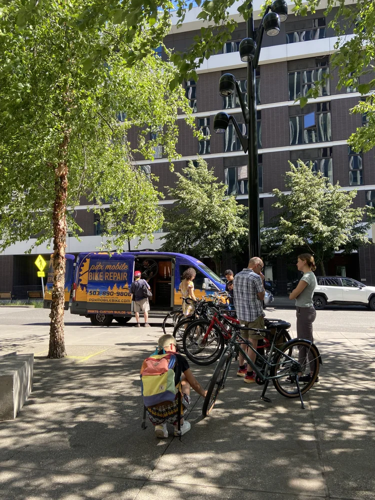 A photo of a group of bikes with somebody doing maintenance.