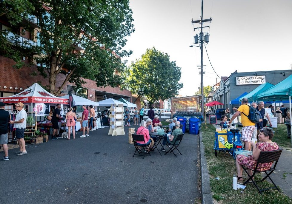 a photo of people sitting at table at a block party