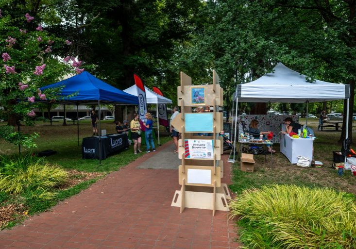 the picture contains some items from the lending library like the community engagement board and canopy tents.