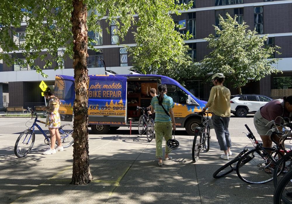 A picture of people getting their bikes repaired.