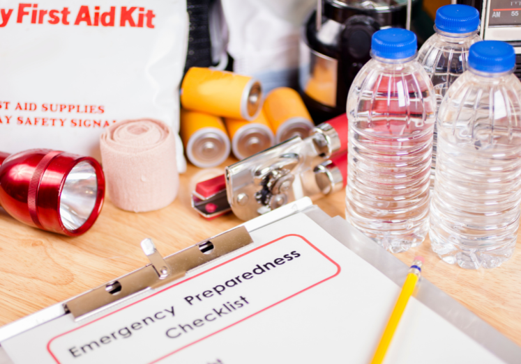 a photo with a checklist showing emergency preparedness supplies on a table with supplies like water, flash light, first aid kit