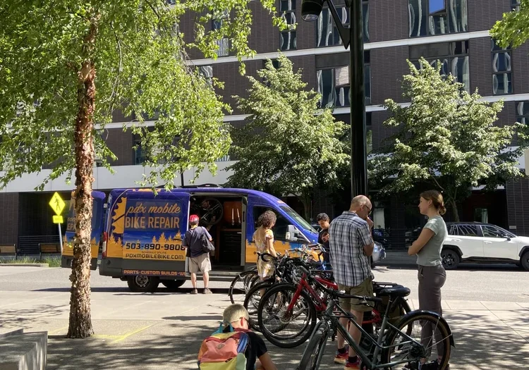 A photo of a group of bikes with somebody doing maintenance.