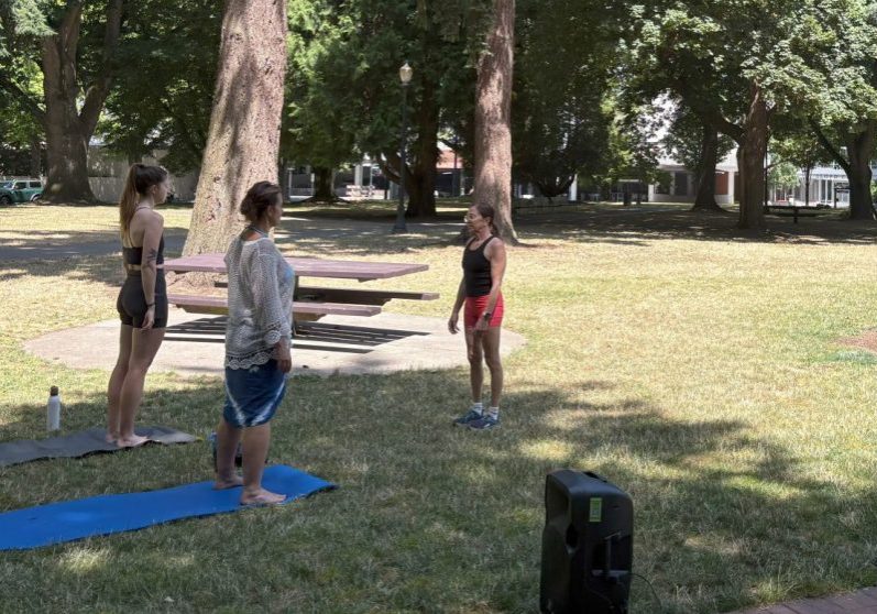 image of three people doing yoga in the park